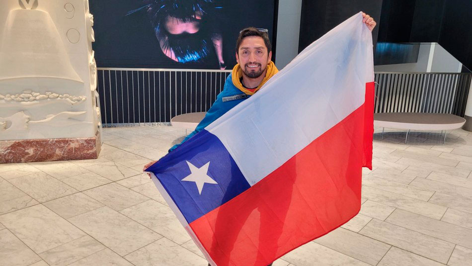 Gustavo Carrera posa con la bandera tras ser el primer chileno en votar en el extranjero