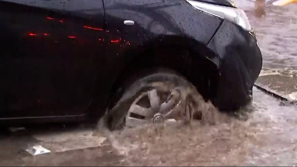 ¡Peligro por lluvias! Auto queda atrapado en socavón lleno de agua en La Cisterna