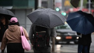 personas caminando bajo la lluvia en Santiago