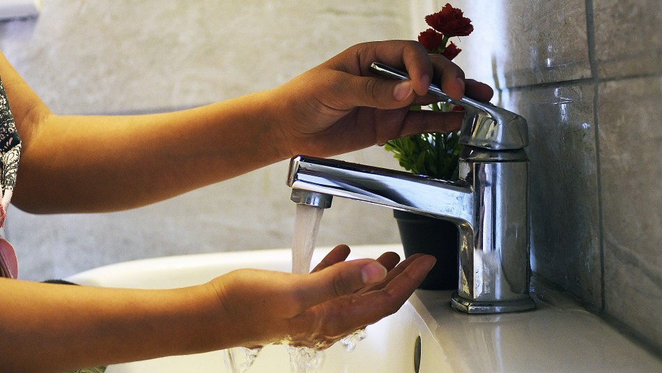 Persona con llave de agua Postergación de pago de cuentas de agua: Conoce cómo acceder al beneficio