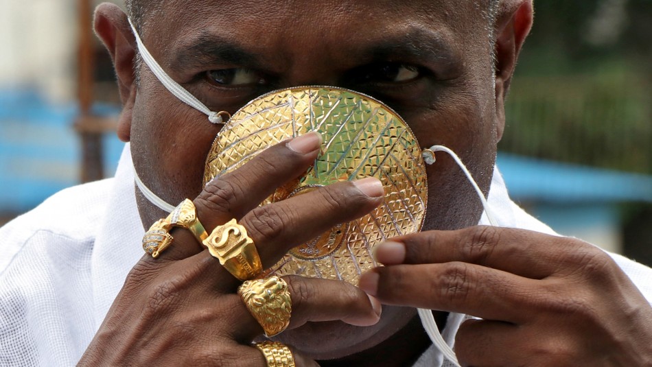 Hombre muestra la primera mascarilla hecha completamente de oro Hombre muestra la primera mascarilla hecha completamente de oro