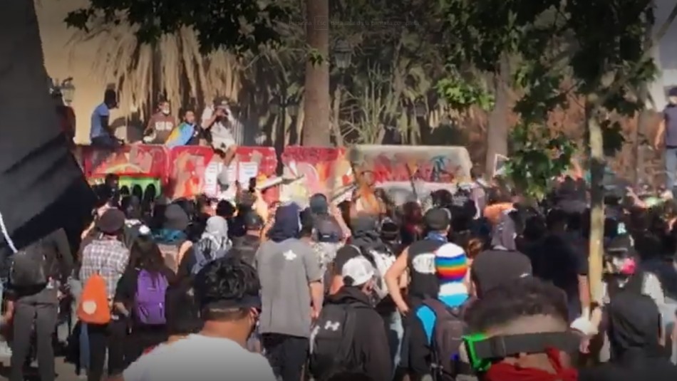 Manifestantes derriban muro que protegía el Monumento a los Mártires de Carabineros Manifestantes derriban muro que protegía el Monumento a los Mártires de Carabineros