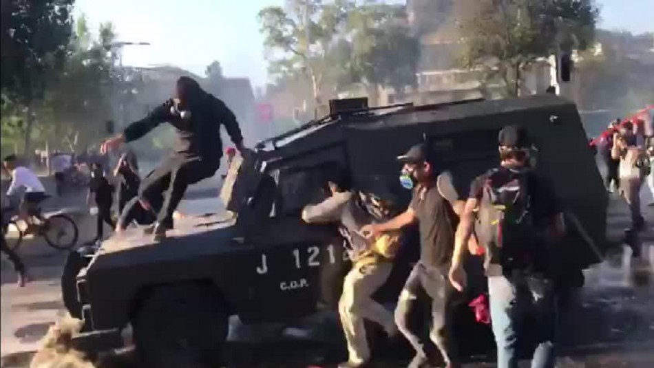 Joven se monta sobre carro lanza gases en movimiento durante manifestaciones en Plaza Italia Joven se monta sobre carro lanza gases en movimiento durante manifestaciones en Plaza Italia