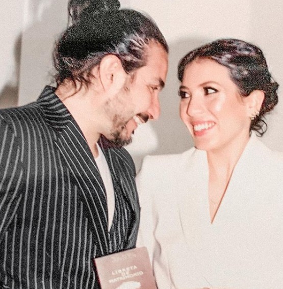 Felipe Avello y Daniela León posando con la libreta de matrimonio