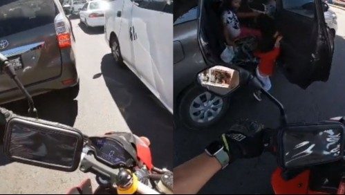 Motocilista capta el momento en que un niño abre la puerta de un auto en movimiento y queda colgando