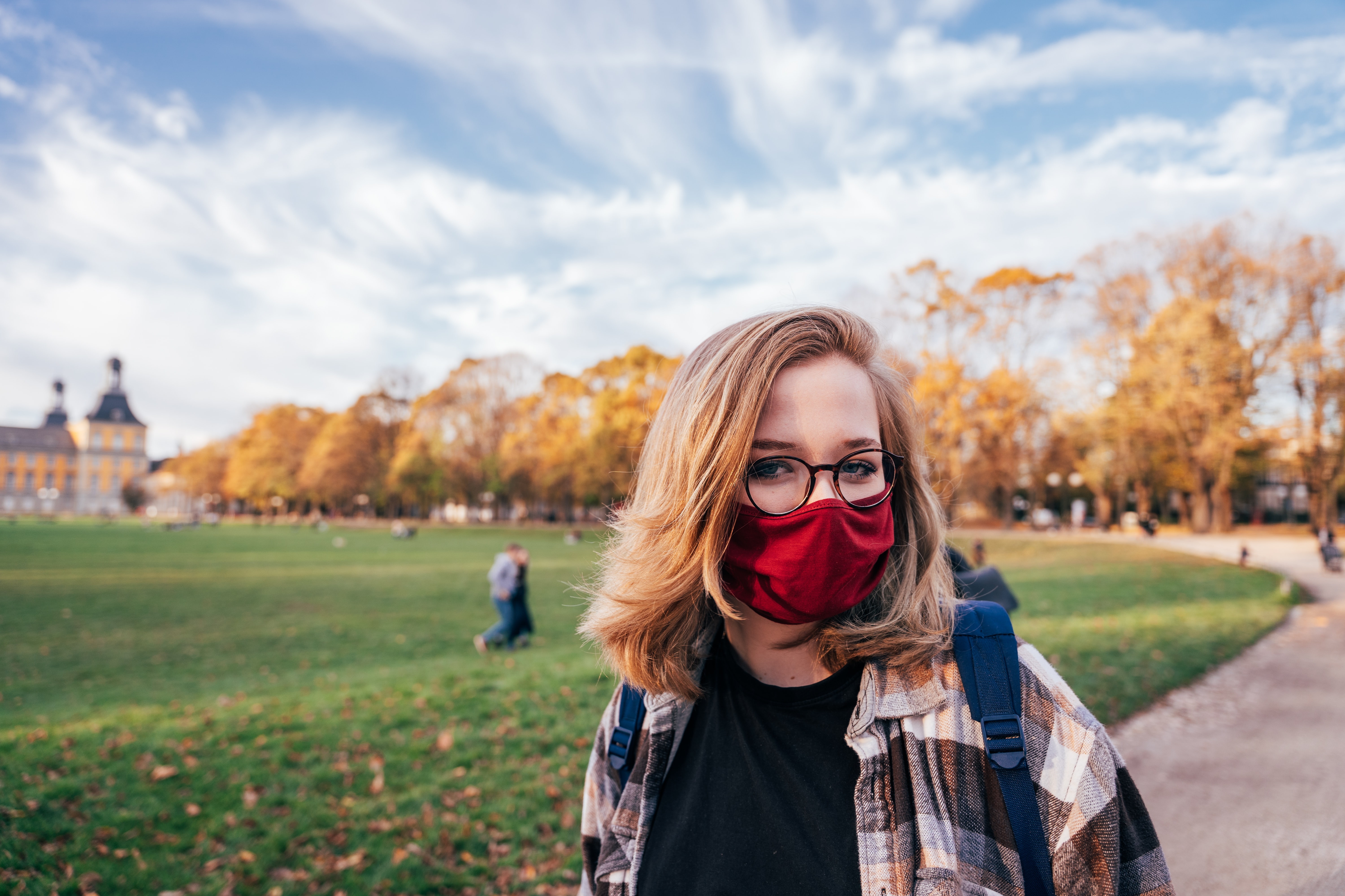 Mujer en un parque usando una mascarilla de tela