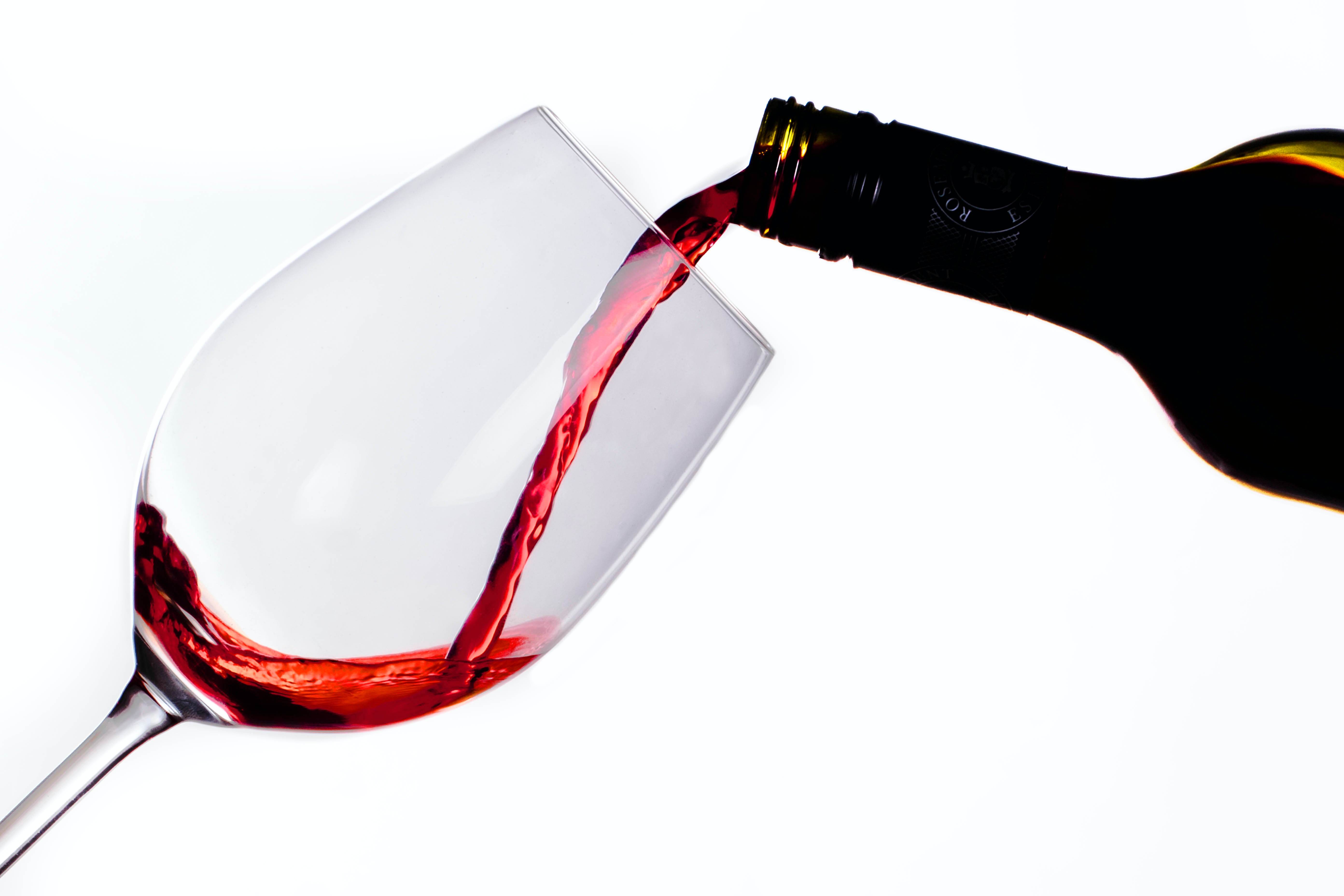 Botella sirviendo vino tinto en copa