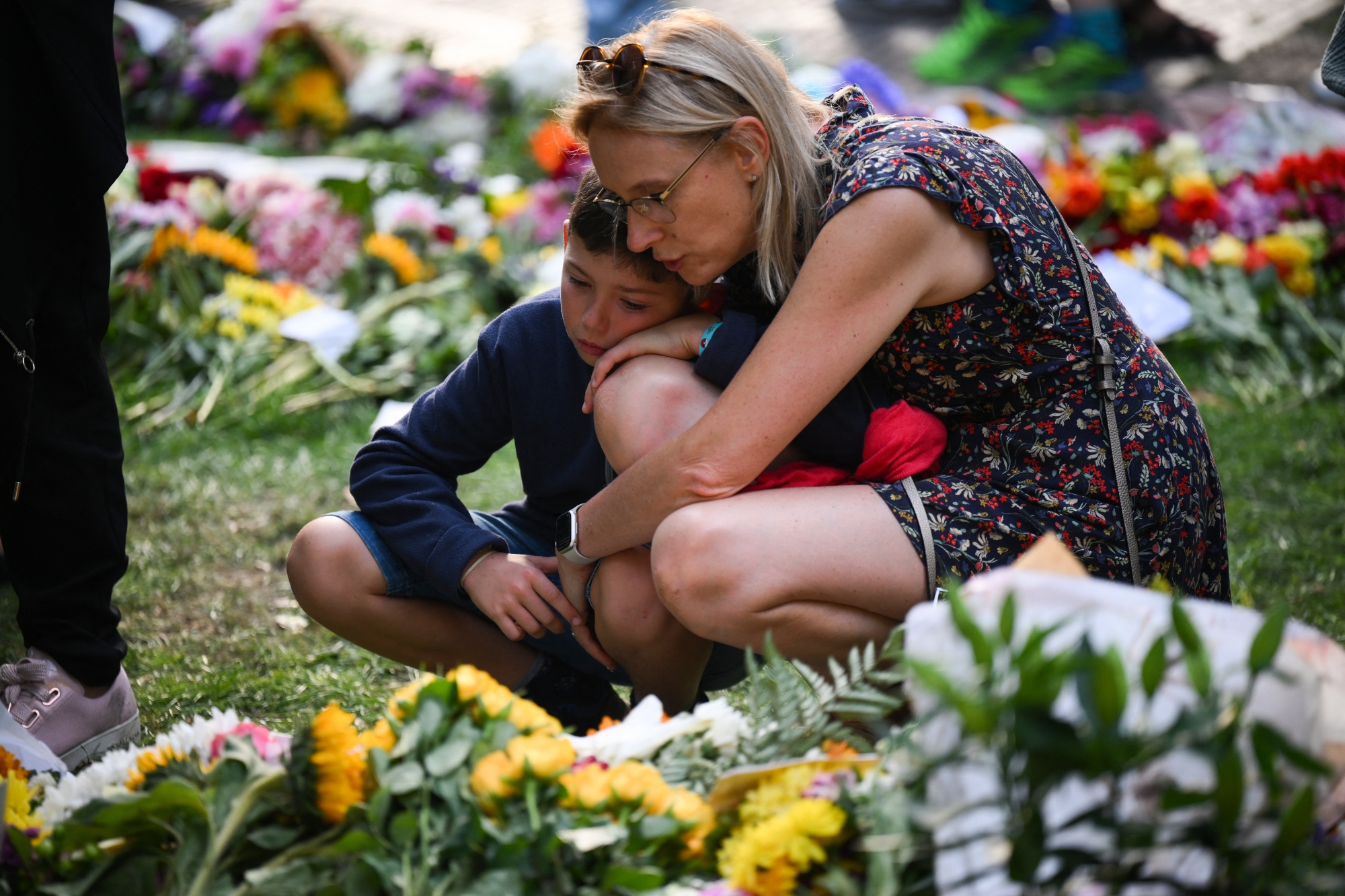 La gente mira las flores colocadas por los simpatizantes en recuerdo de la reina Isabel II de Gran Bretaña en Green Park, cerca del Palacio de Buckingham, en Londres, el 11 de septiembre. Créditos: AFP