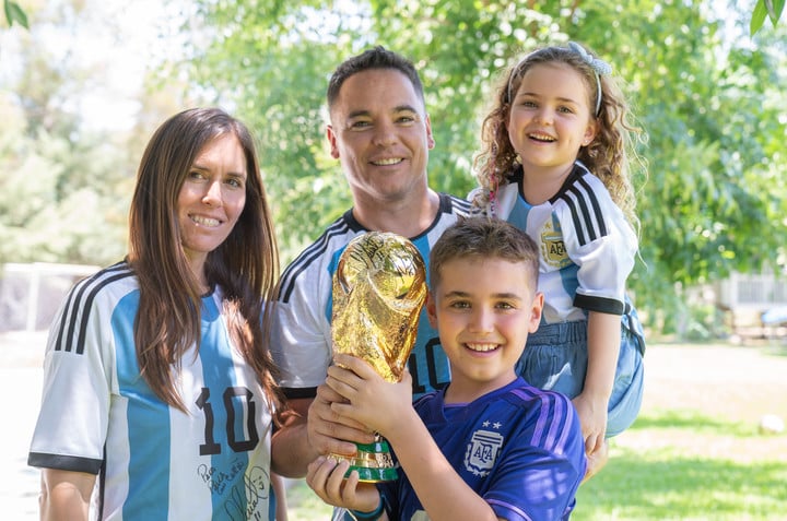 Paula y Manuel junto a sus dos hijos, sosteniendo la copa que levantó Messi. Extraída de Olé.