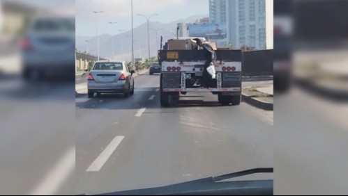 [VIDEO] Hombre se cuelga de un camión y comienza a lanzar la carga a otros vehículos