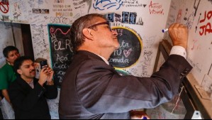 Ministro Marcel come 'completos mojados' en Talca y deja particular dibujo en la pared del local