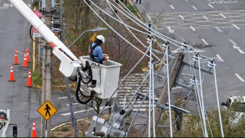 Trabajador de empresa eléctrica revisa el cableado de un poste.