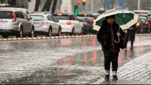 Mujer con paraguas en medio de la lluvia en Santiago.